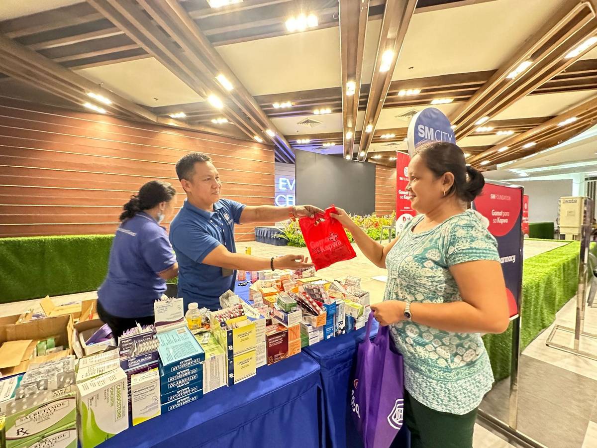 SM Foundation staff hands over free medicines to Loida.